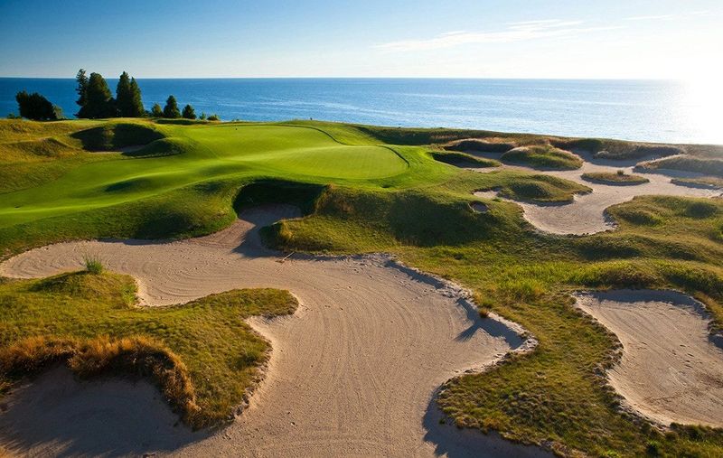 Numerous sand dunes and deep bunkers protect the approach to the par-5 fifth hole, which features a biarritz green (a deep gully bisecting its middle) at Arcadia Bluffs Golf Club along Lake Michigan in Arcadia. The course opened in 1999, designed by Warren Henderson and Rick Smith.