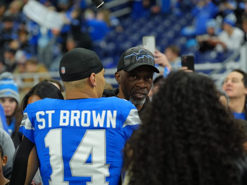 Detroit Lions wide receiver Amon-Ra St. Brown (14) greets his father John Brown and family on the sidelines before the game against the Chicago Bears on Thanksgiving Day at Ford Field in Detroit on Thursday, Nov. 28, 2024.