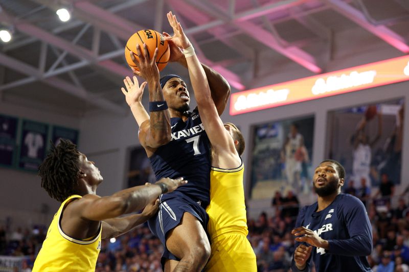 Nov 27, 2024; Fort Myers, Florida, USA; Xavier Musketeers guard Ryan Conwell (7) drives to the basket past Michigan Wolverines forward Will Tschetter (42) in the first half at Suncoast Credit Union Arena. Mandatory Credit: Nathan Ray Seebeck-Imagn Images