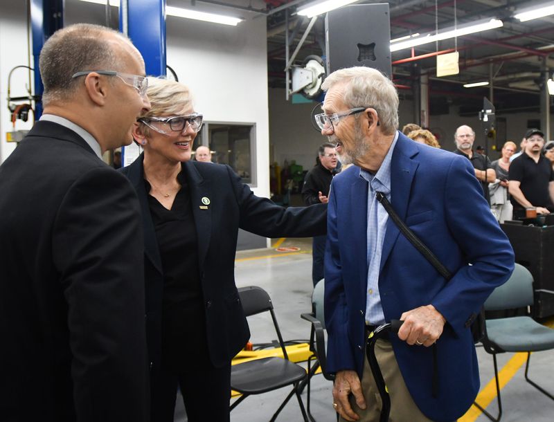 Then-U.S. Secretary of Energy Jennifer Granholm, middle, greets former Lansing Mayor David Hollister, right, as Lansing Mayor Andy Schor looks on, Thursday, July 11, 2024, during a press conference at the General Motors' Lansing Grand River Assembly Plant.