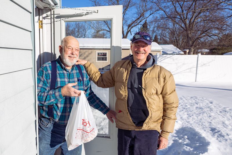 Duane Hallack (left) and Gordy Lesinski (right) pose for a photo during a delivery from Meals on Wheels in Holland.