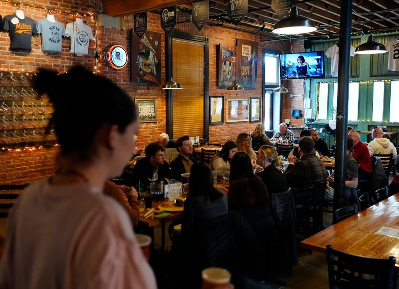 A server heads out with beers as customers eat inside the Mitten Brewing Company in Grand Rapids on Friday, Feb. 14, 2025.
