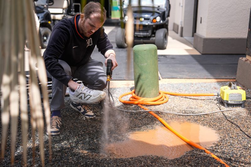 Detroit Tigers clubhouse assistant Frankie Boyd uses a power wash to clean players’ cleats during spring training at Joker Marchant Stadium in Lakeland, Fla. on Thursday, Feb. 20, 2025.