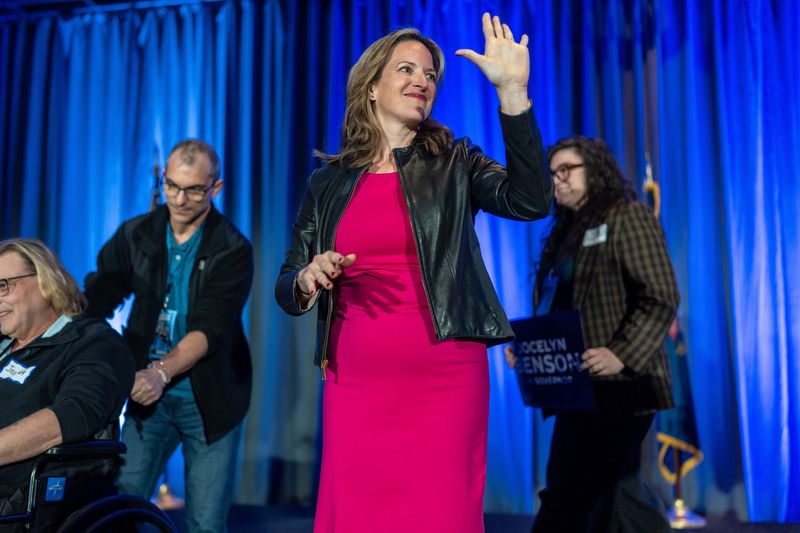 Jocelyn Benson smiles and waves at a large crowd during the Michigan Democratic Party State Convention at the Renaissance Center in Detroit on Saturday, Feb. 22, 2025.
