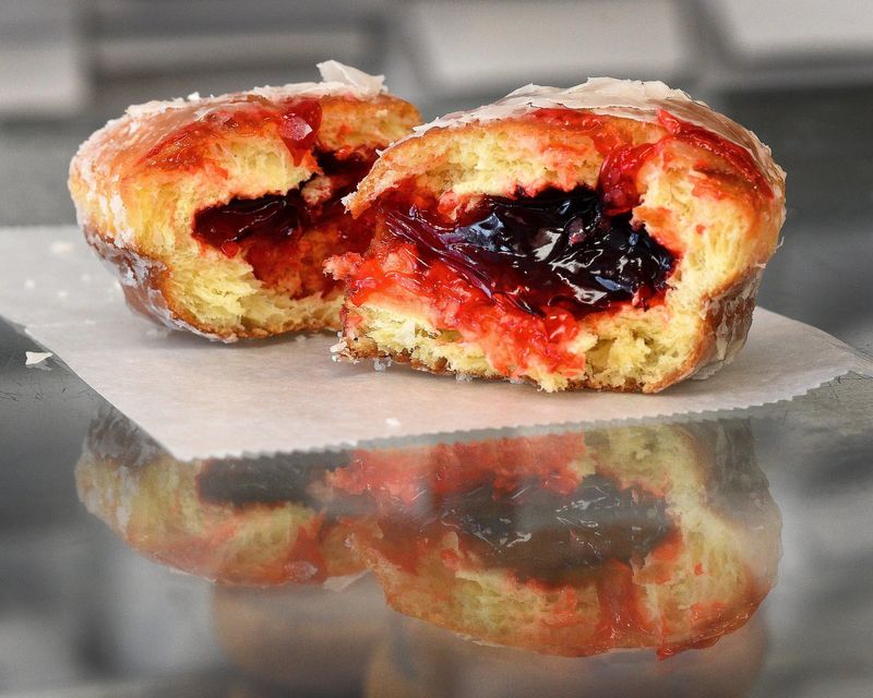 A raspberry paczki is reflected in the glass at Monica's Baker Boy in Monroe, Michigan.