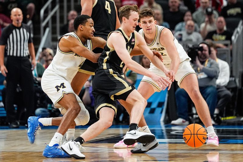 Michigan guard Nimari Burnett (4), left, and forward Will Tschetter (42) defend Purdue guard Fletcher Loyer (2) during the first half of Big Ten Tournament quarterfinal at Gainbridge Fieldhouse in Indianapolis, Ind. on Friday, March 14, 2025.