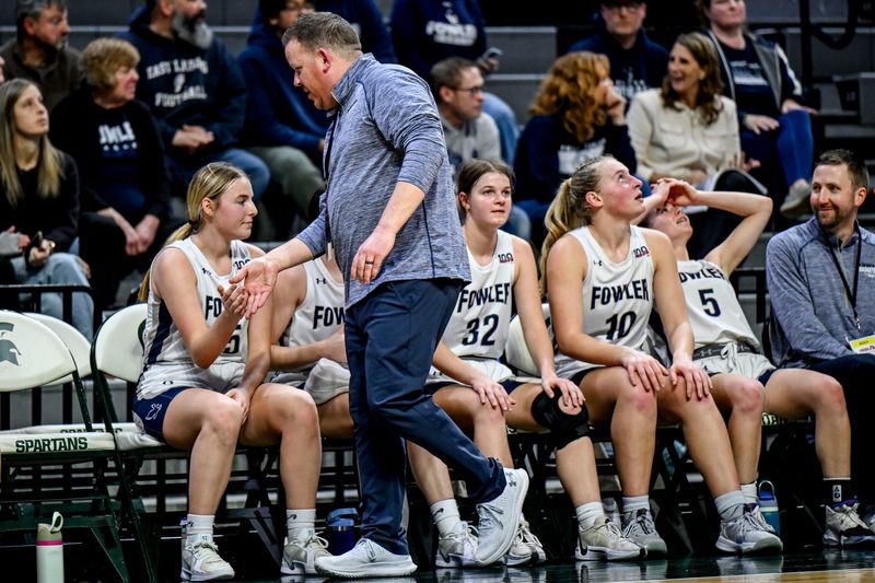 Fowler's head coach Nathan Goerge, center, high fives players as time runs short during the fourth quarter on Thursday, March 20, 2025, in the Division 4 state semifinal against Genesee Christian at the Breslin Center in East Lansing.