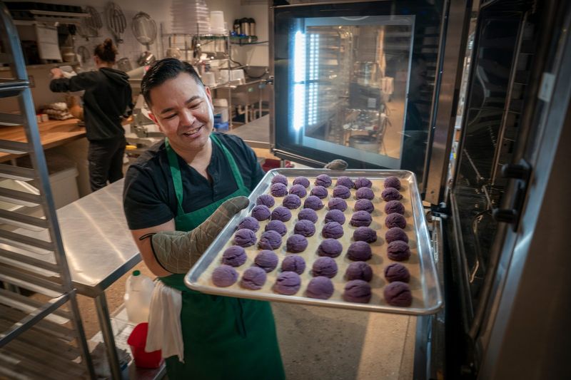 JP Makes and Bakes owner Jonathan Peregrino pulls out a tray of ube cookies fresh from the oven at his bakery in Detroit on Wednesday, March 19, 2025. Peregrino infuses his Filipino roots directly into everything he creates at his Detroit bakery.