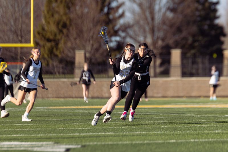 Zeeland’s Audrey Durham takes the ball up the field against a West Ottawa defender on Wednesday, March 26.