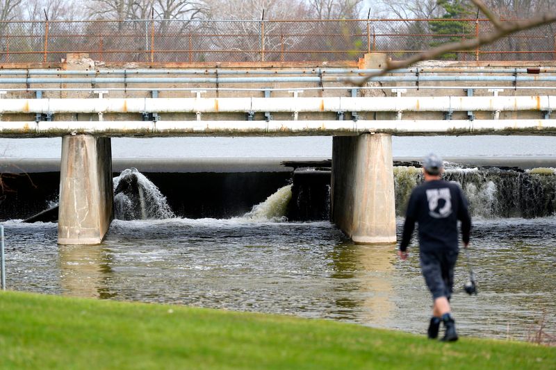 A fisherman heads toward the Flat Rock dam in Flat Rock on Friday, April 18, 2025.