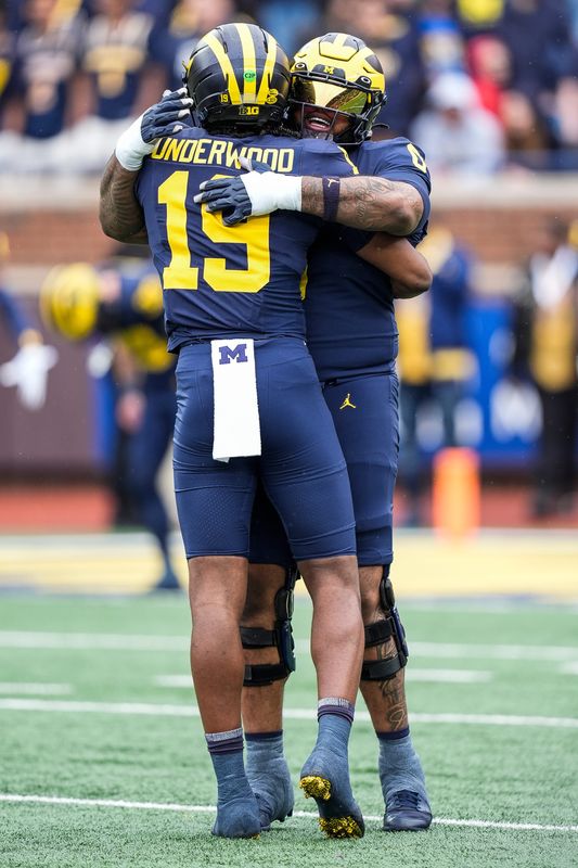 Michigan quarterback Bryce Underwood (19) hugs defensive lineman Tré Williams (0) before the first half of the spring game at Michigan Stadium in Ann Arbor on Saturday, April 19, 2025.