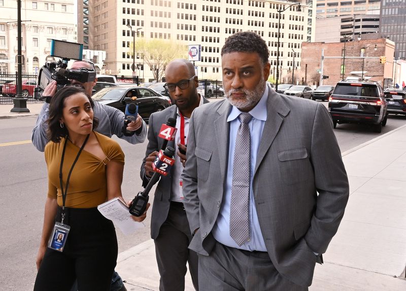 Members of the media pepper former Detroit Riverfront Conservancy CFO William Smith, right, with questions, which he did not answer, as he leaves federal court after being sentenced to 19 years for stealing more than $44 million from the nonprofit in Detroit, Michigan, on April 24, 2025.