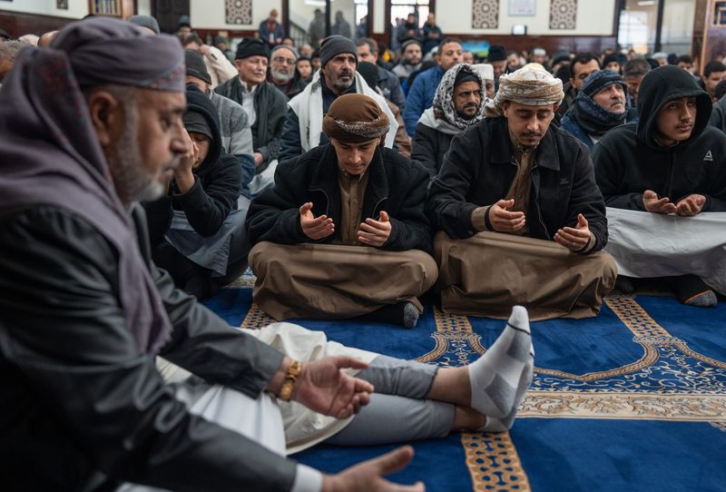 A room full of men take part in prayer during an afternoon service at the Islamic Center of Hamtramck on Friday, Feb. 14, 2025.