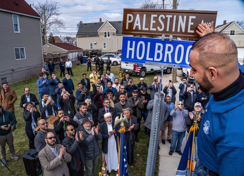 Hamtramck City Council member Khalil Refai unveils the sign for a renamed street during a ceremony on Thursday, March 7, 2024, at the corner of Holbrook Avenue and Gallagher Street. The City Council had voted to designate the road as "Palestine Avenue."
