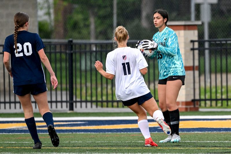Grand Ledge's goalkeeper Lilli Nichols, right, picks up a ball kicked by Mason during the first half on Tuesday, May 13, 2025, in the CAAC Gold Cup game in Grand Ledge.