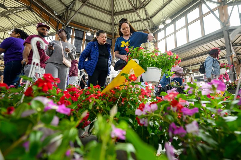 People shop for petunias during Eastern Market's annual Flower Day, in Detroit, May 18, 2025.
