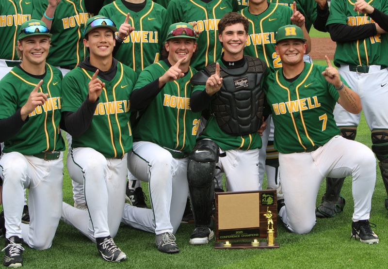 Howell players celebrate with the trophy after beating Hartland 6-1 in the KLAA baseball championship game Thursday, May 22, 2025 at Novi High School.