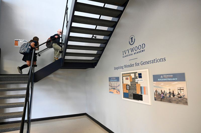 Ivywood Classical Academy students Josephine Edelson, 11, left, and Judah Edelson, 10, walk up the stairs to their respective classrooms as they arrive at the Plymouth charter school on Friday, May 23, 2025.