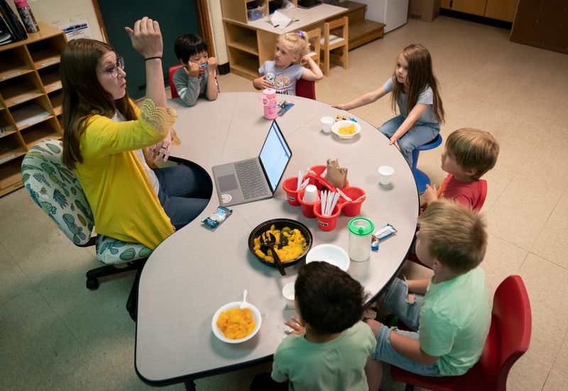 Great Start Readiness Program lead teacher Kirstyn Love works with her students as they eat breakfast at Early Childhood and Kids Club Program in Whitmore Lake on Friday, May 30, 2025.