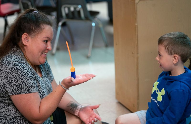Great Start Readiness Program (GSRP) teacher helper Cassie Villarreal plays a game with a student at Early Childhood and Kids Club Programs in Whitmore Lake on Friday, May 30, 2025.