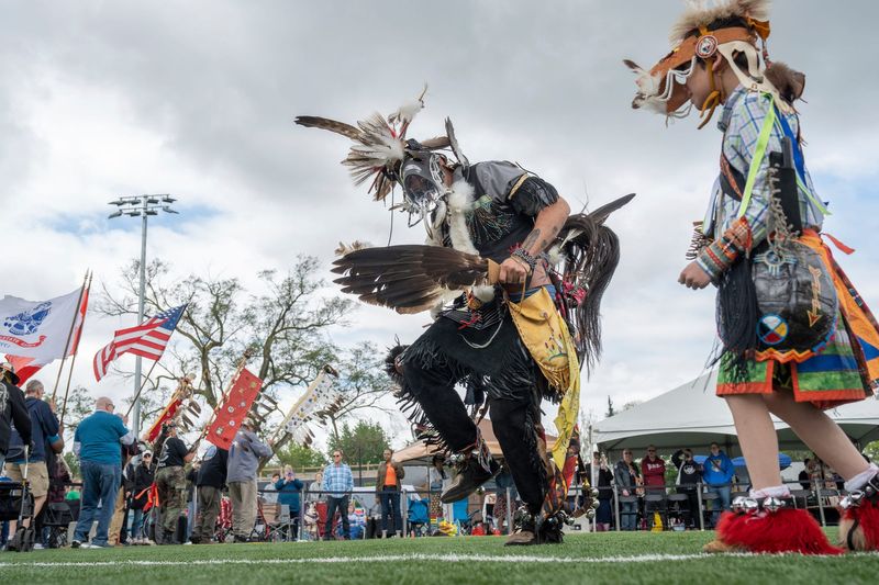 Sault Tribe of Chippewa Indians member Mike Hatch, center, of Sault Ste. Marie, dances with his son Arrow Hatch, while taking part in the opening procession during the annual "Pow Wow in the D" put on by the American Indian Health and Family Services at Wayne State University Intramural Field in Detroit on Saturday, May 17, 2025.