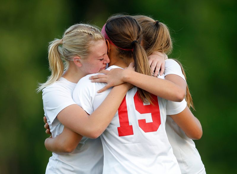 Laingsburg's Allie Brasseur, left, Gwenith Clark, center, and Kierra Rusz hug after their loss to Plymouth Christian Academy, Thursday, June 5, 2025, at Lansing Christian High School.