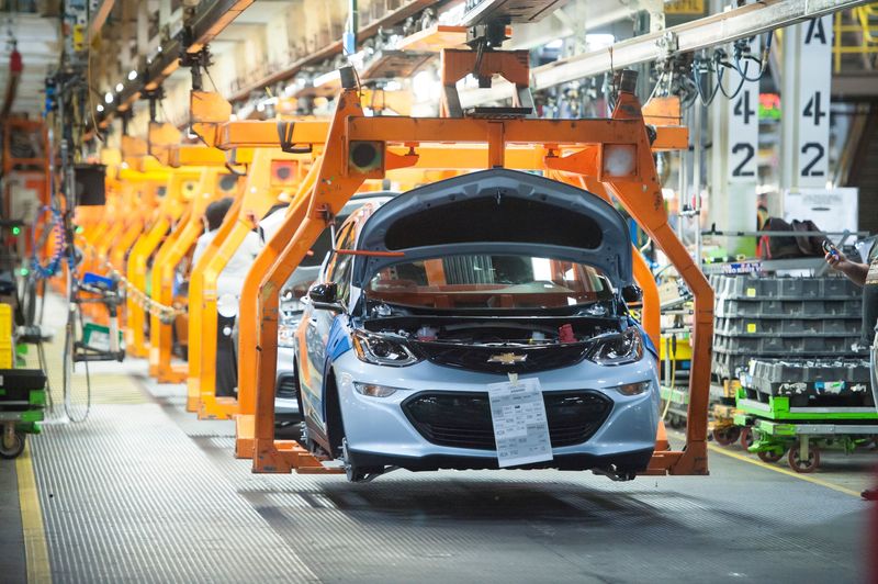 A battery-electric Chevrolet Bolt EV makes its way down the line at General Motors Co.'s Orion Assembly during the EV's first run. As part a $4 billion investment, the refurbished plant will build a luxury SUV and full-size pickups instead of a planned electric truck.
