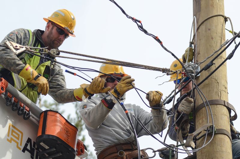Consumers Energy line workers help restore damaged power lines in Pellston on April 3, 2025.