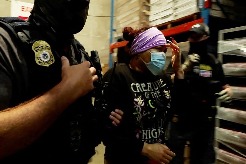 A woman is detained during a raid by Immigration and Customs Enforcement (ICE) at a meat production plant in Omaha, Nebraska.