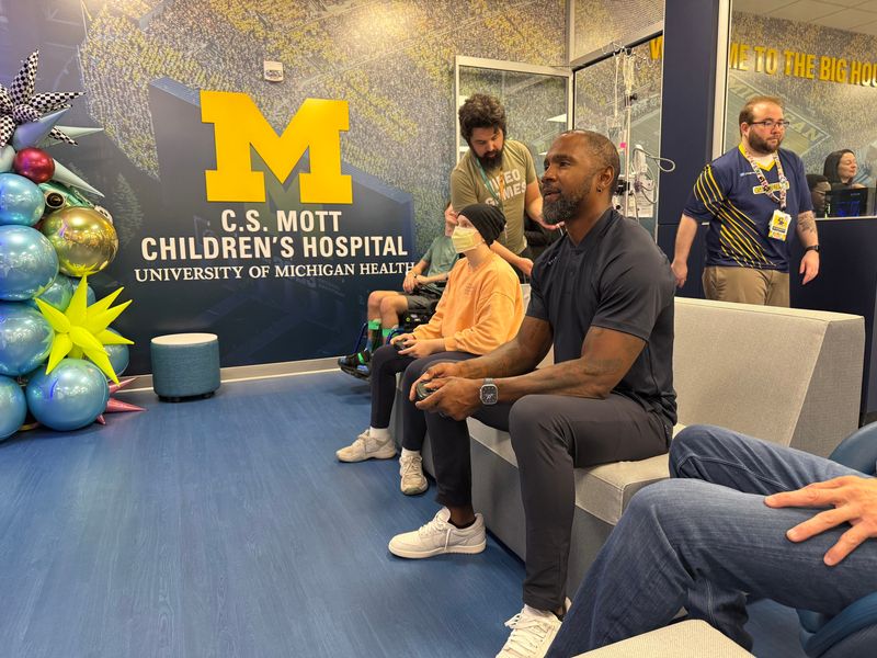 Charles Woodson plays a video game at the ribbon cutting for the Michigan Gameday Experience at C.S. Mott Children's Hospital on Thursday, June 19, 2025