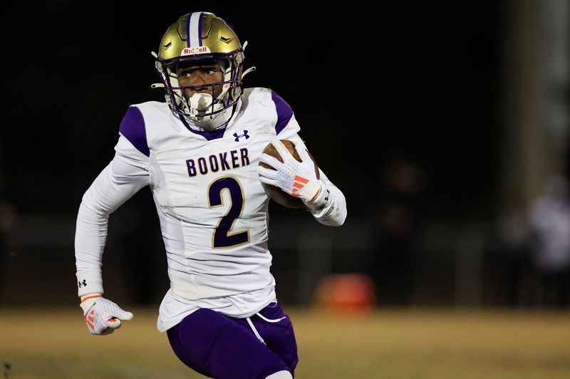 Booker's Tyren Wortham (2) rushes for yards during the first quarter of an FHSAA Class 3A state football semifinal matchup Friday, Dec. 6, 2024 at Raines High School in Jacksonville, Fla.