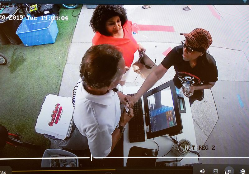 A video still shows Detroit 36th District Judge Demetria Brue, right, reach to take her receipt from a worker during a 2019 incident at a Mackinac Island bike shop after the bike of 46th District Judge Debra Nance, center, didn’t work.