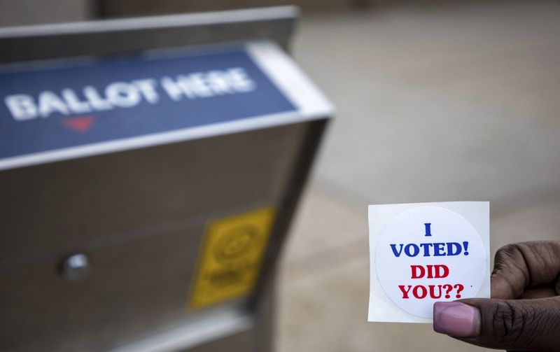 Armoni McTaw of Detroit holds an I-voted sticker early morning in front of the Detroit Department of Elections in Detroit on Tuesday, Nov. 8, 2022.
