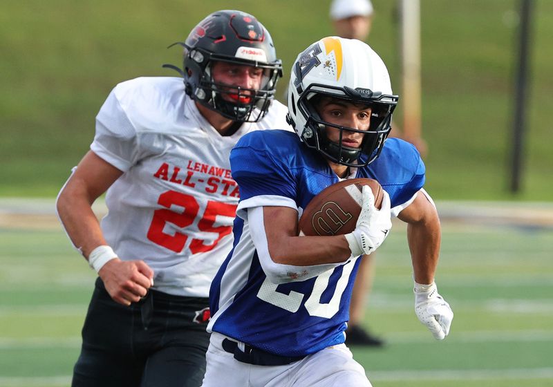 Erie Mason's Michael Narew runs away from Jake Felts of Clinton during the Monroe County vs. Lenawee County All-Star Football Game at Adrian College on Friday, June 20, 2025.