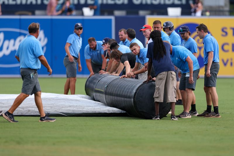 Tampa Bay Rays grounds crew rolls up the tarp after a rain delay against the Detroit Tigers in the ninth inning at George M. Steinbrenner Field in Tampa, Florida on Sunday, June 22, 2025.