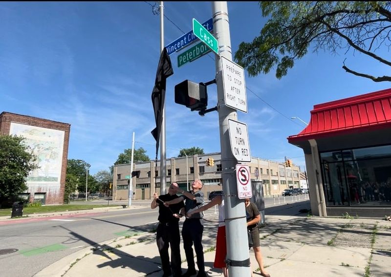 Richard Mui of Association of Chinese Americans; Roland Hwang, president of American Citizens for Justice; State Sen. Stephanie Chang, D-Detroit, and Detroit councilwoman Gabriela Santiago-Romero pull down a black covering to unveil the new street sign renaming Peterboro Street on corner of Cass Avenue as Vincent Chin Street on June 23, 2025, the 43rd anniversary of his death in a case that sparked Asian American activism.