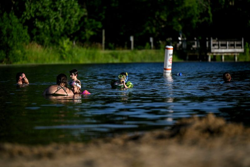 Park patrons cool off in the lake at Fox Memorial Park on Monday, June 23, 2025, in Potterville.