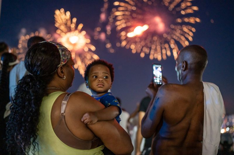 Deaonca Pittman, of Detroit, holds her grandson Amir Sumbry at Hart Plaza in downtown Detroit while watching the 2025 Ford Fireworks on Monday, June 23, 2025.
