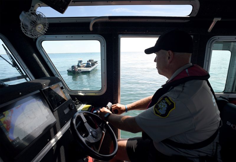 Monroe County Sheriff jail Sgt. Sean Romstradt with the Marine Division pulls up along a fishing boat with his partner Assistant Jail Administrator Lt. Chad Cupp as the boat was inside the Fermi Exclusion Zone on Lake Erie Tuesday, July 1, 2025.