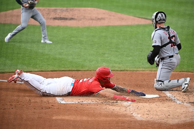 Washington Nationals second baseman Luis Garcia Jr. (2) slides head first into home to score a run in front of Detroit Tigers catcher Dillon Dingler (13) during the first inning of Game 2 of a split doubleheader at Nationals Park in Washington on Wednesday, July 2, 2025.