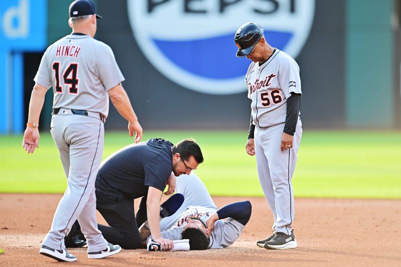 Detroit Tigers third base coach Joey Cora (56) and manager A.J. Hinch (14) and medical personnel look at second baseman Gleyber Torres (25) during the first inning against the Cleveland Guardians at Progressive Field in Cleveland on Saturday, July 5, 2025.