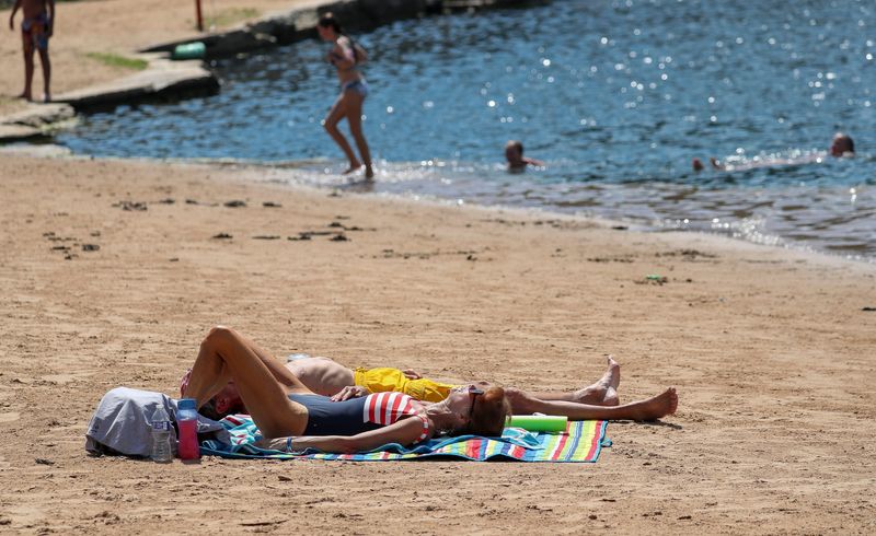 Beachgoers lie down to tan on Tuesday, July 1, 2025, at Duck Creek Quarry in Howard, Wis. 
Tork Mason/USA TODAY NETWORK-Wisconsin