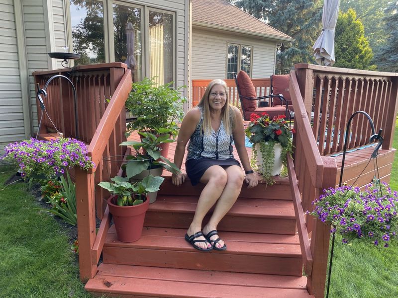 Fran Uhrman is shown in her backyard garden. She and her husband, John, care for many plants, including a century-old family peony bush. The Uhrmans' garden is one of five on July 12's Bedford Flower and Garden Club's Garden Tour.