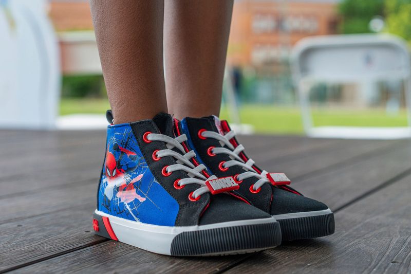 Journey Cochran, 8, of Novi wears Spiderman shoes for Samir Grubbs, a 4-year-old shot and killed in a drive-by shooting at Skinner Park last month, on Saturday, July 12, 2025 at Skinner Park in Detroit.