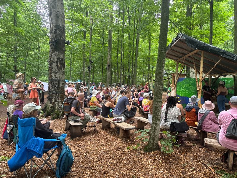 People take a seat to see Spencer LaJoye perform at the Song Tree, accompanied by Chris DuPont and Kylee Phillips, during Blissfest on Saturday, July 12, 2025.