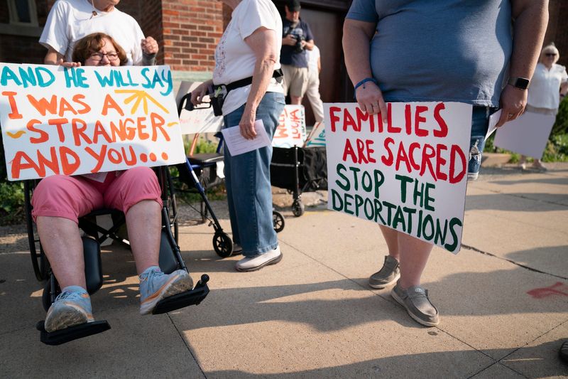 Marge Sears, of Berkley, left, joins a group of Catholics and others who support immigrants “Strangers No Longer” walk from the historic Most Holy Trinity Catholic Church in Corktown on Monday, July 14, 2025 to deliver a letter to the Detroit ICE regional field office director Kevin Raycraft, asking for individuals be treated with dignity. Hundreds prayed during the protest for family members who have recently been detained or deported by ICE.