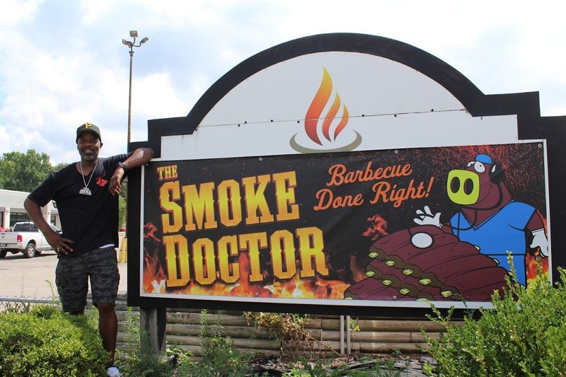Cornell Clark, owner of The Smoke Doctor, poses in front of the banner at 1202 E. Grand River Ave. in Howell on July 16, 2025.