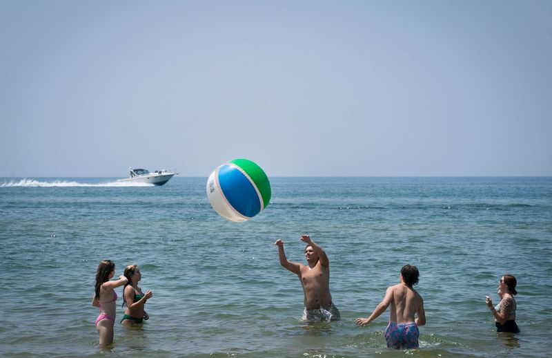 Beachgoers in South Haven toss an oversized beach ball as they swim in Lake Michigan at their own risk on Tuesday, July 15, 2025. Lake Michigan is the deadliest lake in America, statistics show. Yet there are no lifeguards at 99% of Michigan's public beaches.