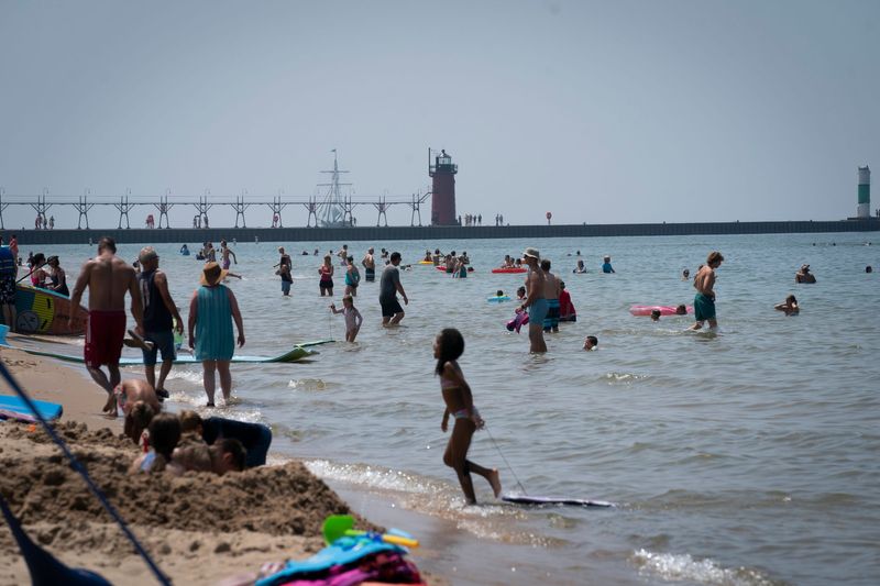Beach goers in South Haven swim in Lake Michigan at their own risk on Tuesday, July 15, 2025. Lake Michigan is the deadliest lake in America, statistics show. Yet there are no lifeguards at 99% of Michigans public beaches.