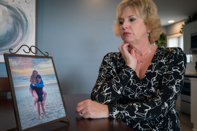 Lisa MacDonald, 57, of Chesterfield Township photographed at her home on Tuesday May 6, 2025, with a photo of her late daughter Emily and her boyfriend Kory Ernster.